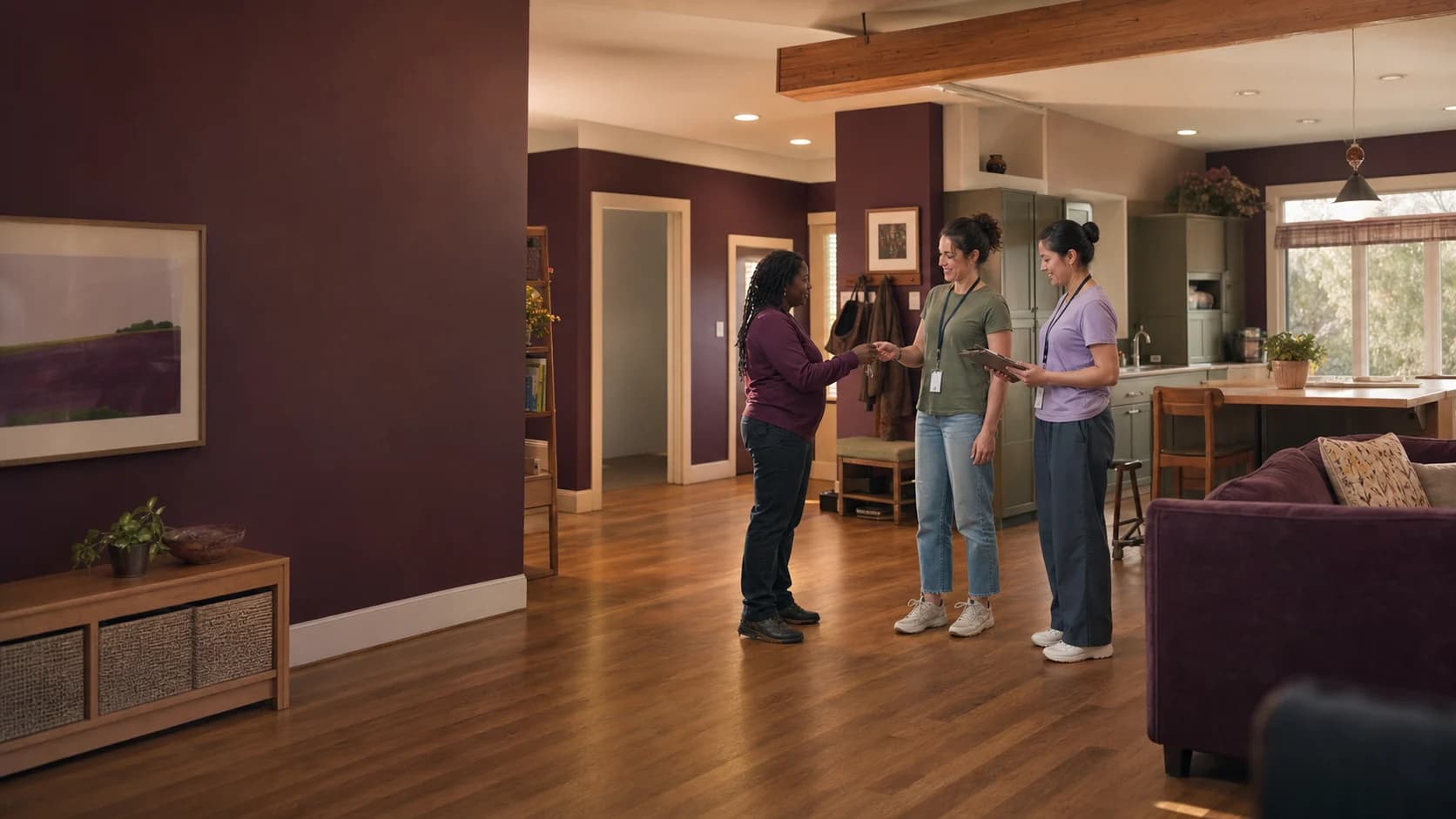 Three residential-care coworkers exchange house keys during a shift change