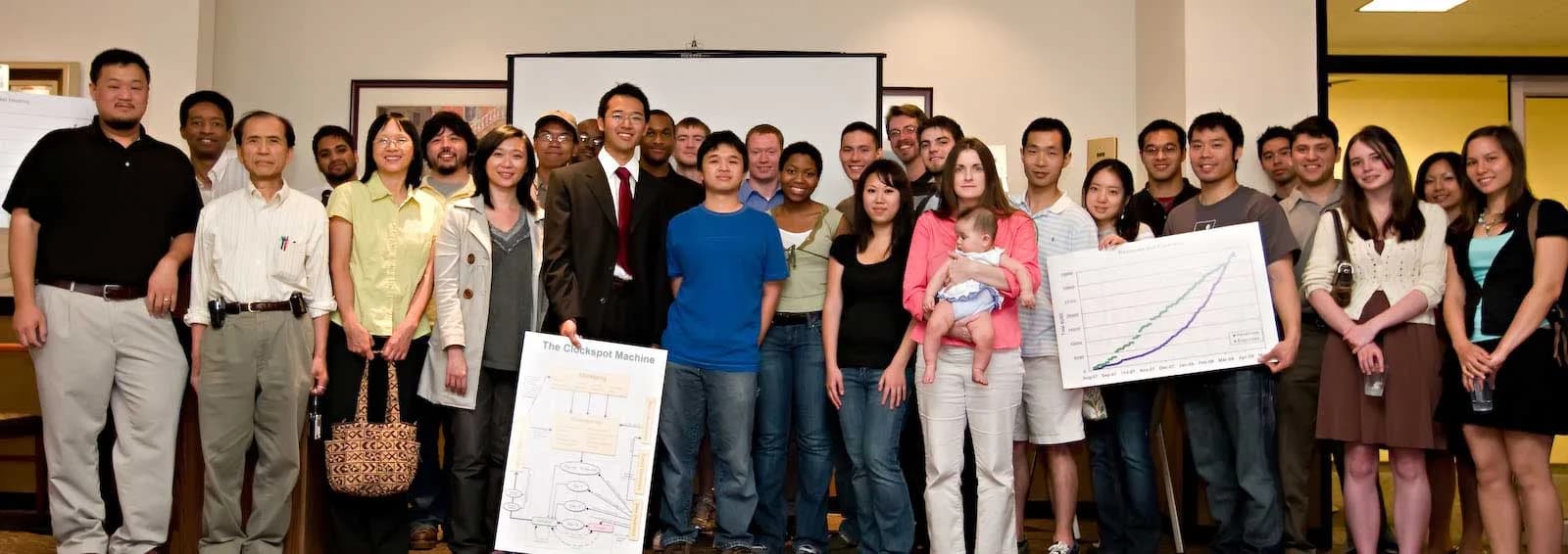 Everyone working on Clockspot in 2008, photographed together holding a hand-drawn diagram of how the product worked.