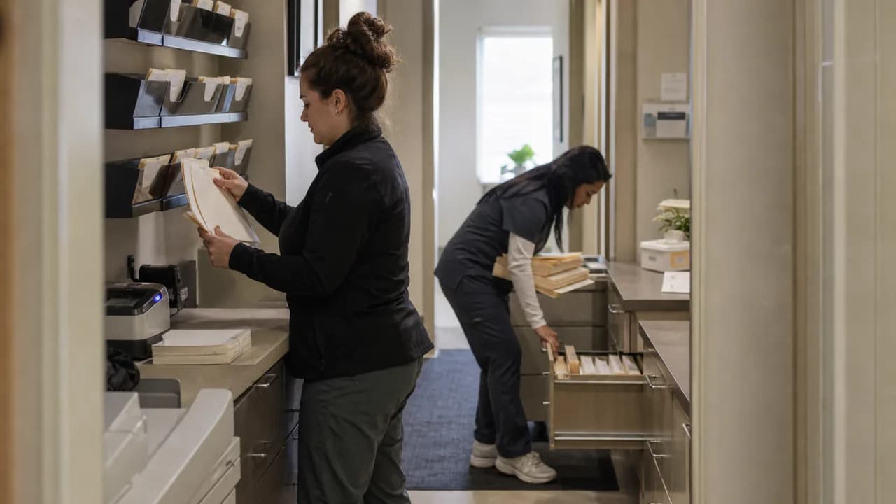 Two clinic employees preparing patient records before opening