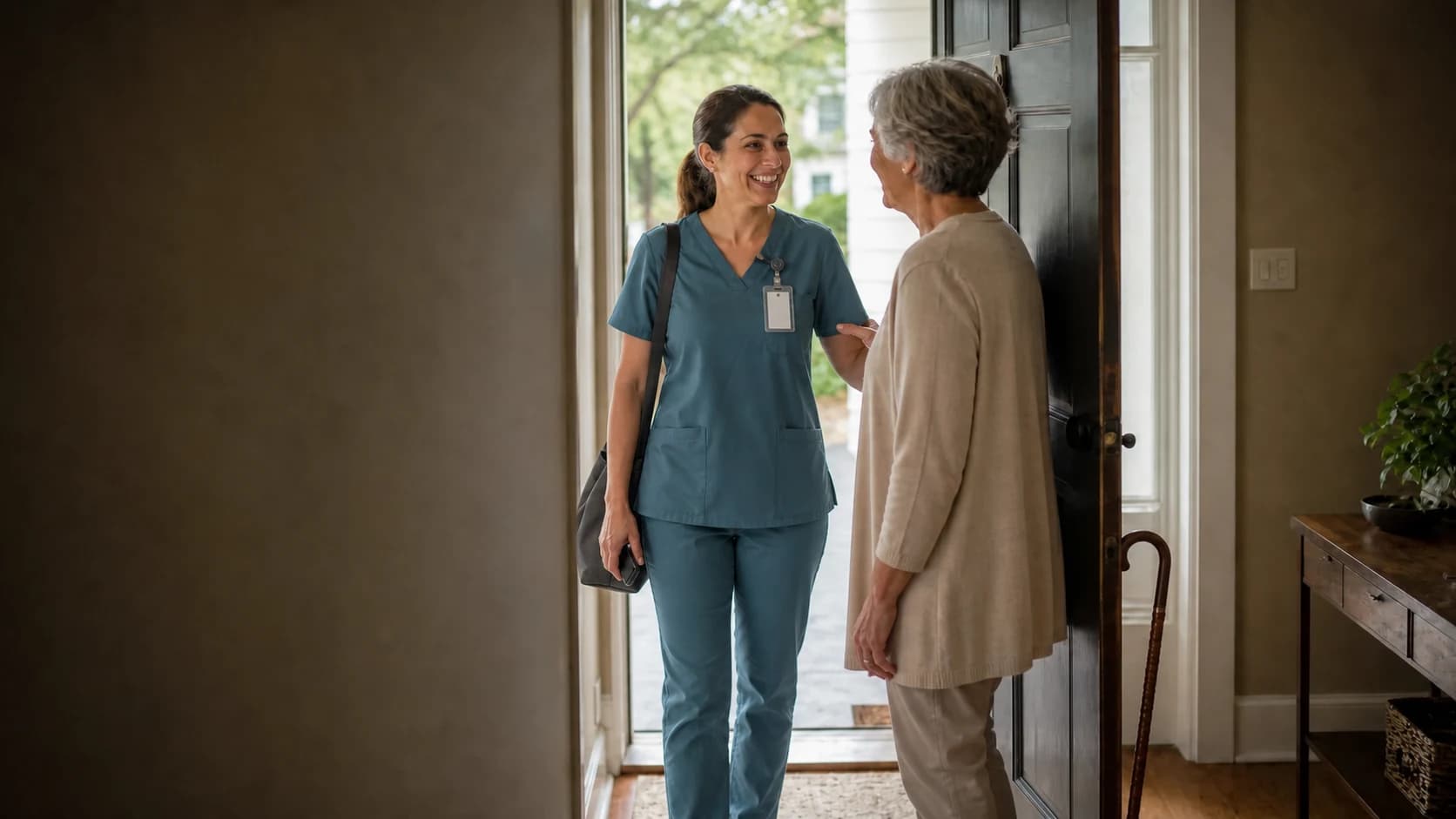 A caregiver greeting a client at the front door of her home